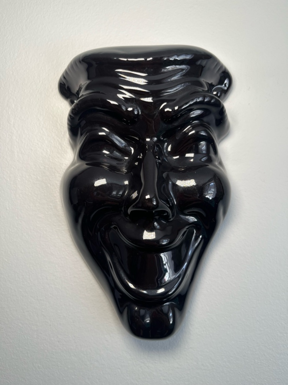 Vintage black ceramic "Smile Now Cry Later" decorative mask.